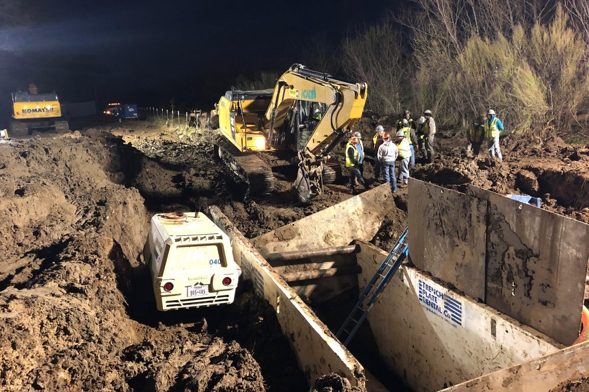 Night-time emergency utility repair with an excavator and trench box