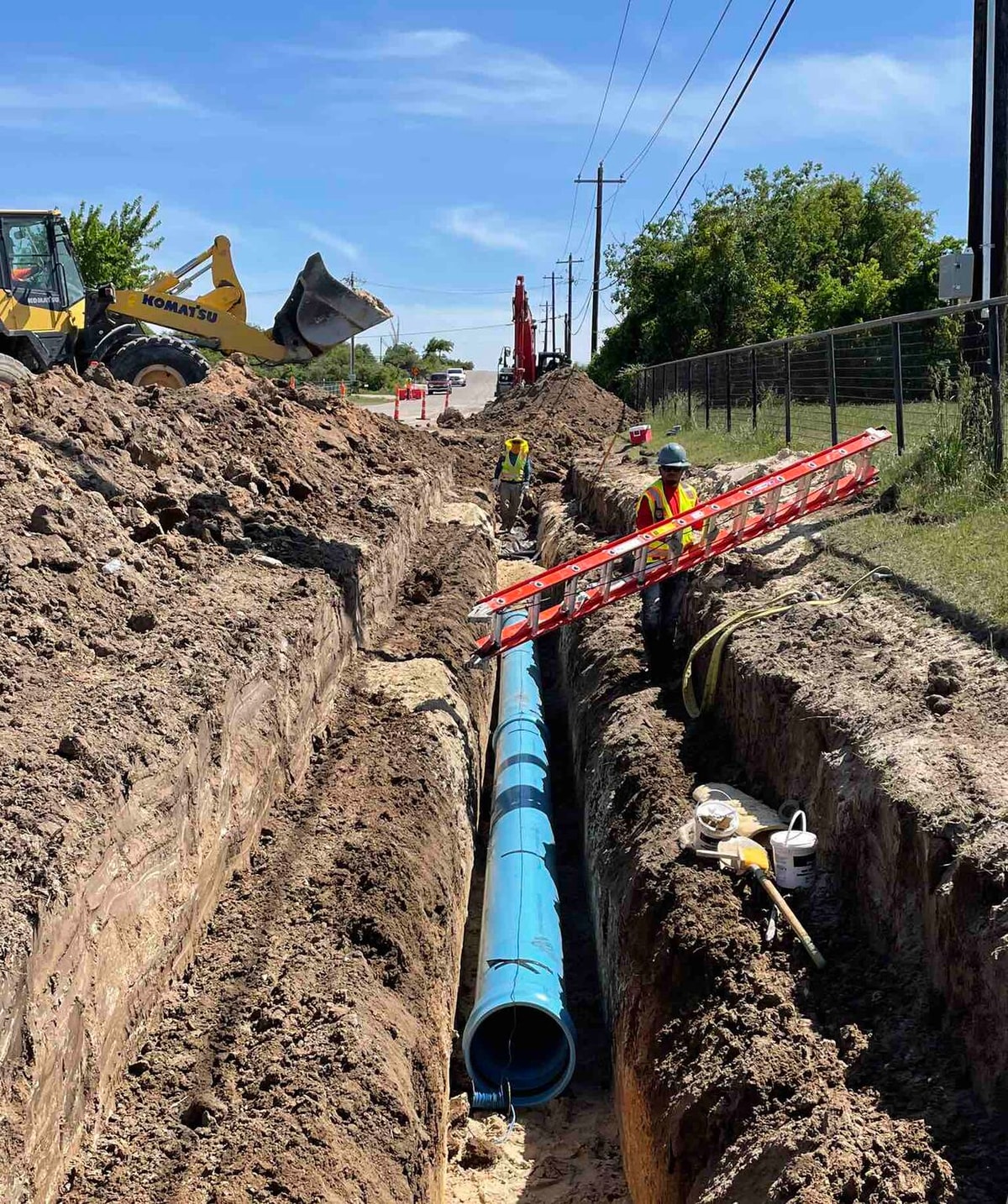 Blue water line pipe laid in a trench beside a road