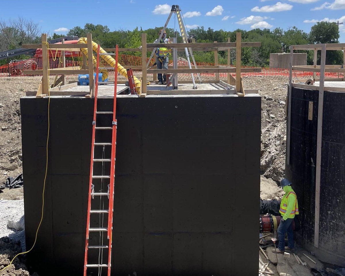 Concrete wet well structure with access ladder under construction
